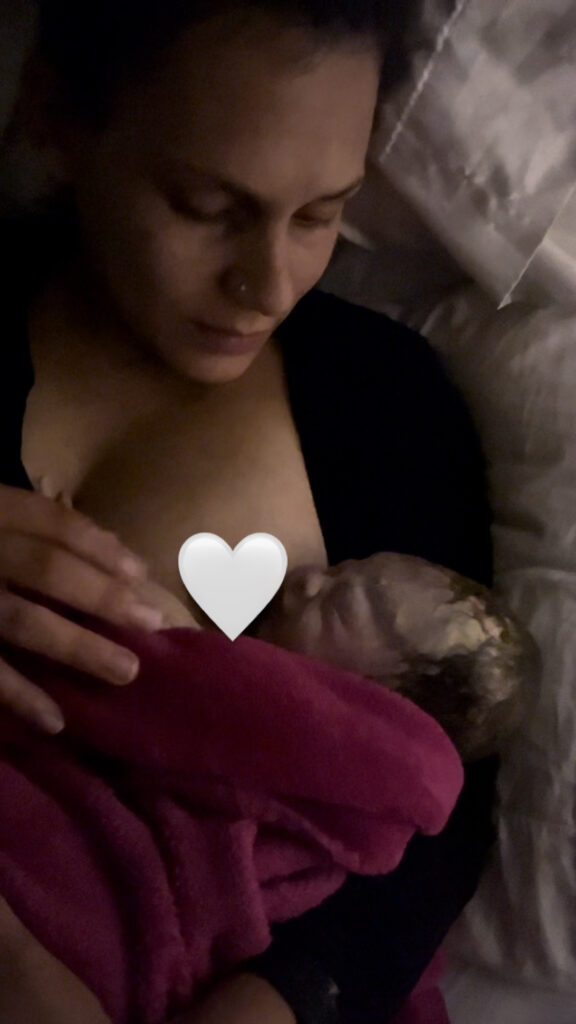 Picture of woman holding her newborn baby after an unplanned unassisted positive home birth